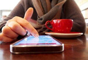 woman scrolling with coffee cup in front of her