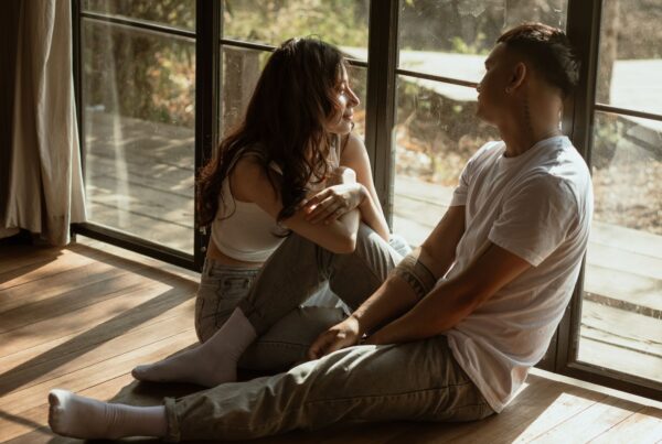 couple talking by sliding door, sitting on the floor