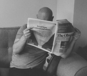 bald man reading newspaper, black and white