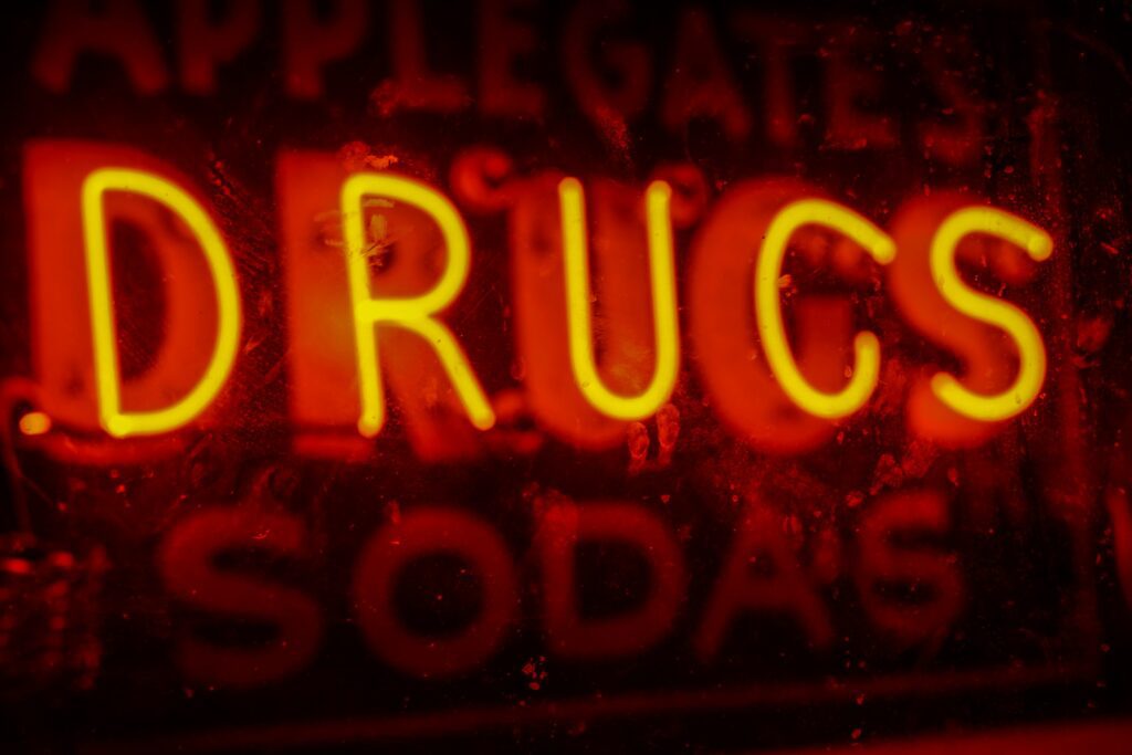 neon light sign saying drugs